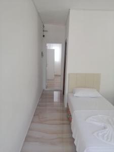 two beds in a white room with a hallway at Kiriş Banana Suit in Kemer
