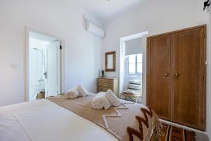 a bedroom with a bed with towels on it at Casa Ladeira in Loulé +23 photos