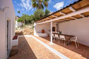 an outdoor patio with a wooden table and chairs at Casa Ladeira in Loulé