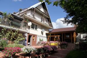 a house with flowers in front of it at Pokoje Sowa Domek Sowa in Mikołajki