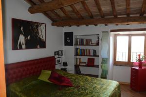 1 dormitorio con cama roja y estante para libros en La Casa di Zoe al borgo, en Perugia
