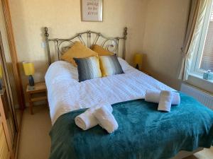 a bed with two towels sitting on top of it at Mojo in Ilfracombe