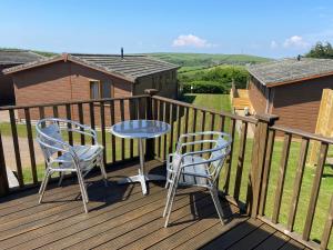 a patio with two chairs and a table on a deck at Mojo in Ilfracombe