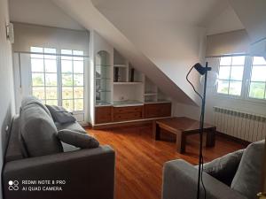 salon z dwiema kanapami i stołem w obiekcie Duplex en Sanxenxo con piscina y vistas al mar w mieście Sanxenxo