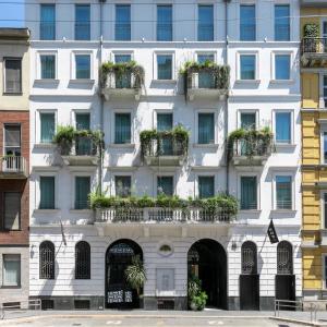 een wit gebouw met potplanten erop bij Senato Hotel Milano in Milaan