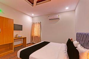 Dormitorio con cama, escritorio y TV en Super OYO Flagship RBS Classic Stay Boduppal, en Hyderabad