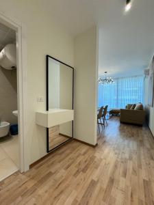 a living room with a mirror and a couch at Tirana Primo Apartment in Tirana