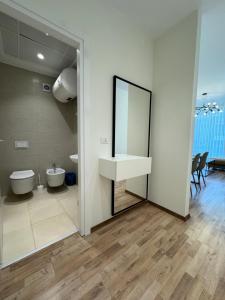 a bathroom with a sink and a toilet and a mirror at Tirana Primo Apartment in Tirana