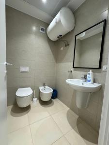 a bathroom with a toilet and a sink and a mirror at Tirana Primo Apartment in Tirana