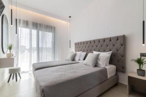 a bedroom with a large bed with a large window at SunWhite Villas - Private Pool & Cozy Atmosphere, by ZanteWize in Laganas