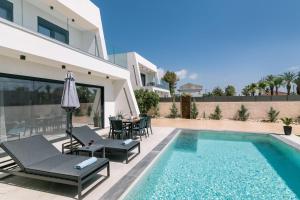 a villa with a swimming pool and a house at Sun White Villas in Laganas