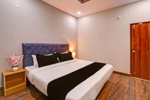Schlafzimmer mit einem großen Bett mit blauem Kopfteil in der Unterkunft Super OYO Flagship RBS Classic Stay Boduppal in Hyderabad