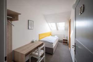 una camera da letto con un letto e una scrivania di Hotel u Budvaru a České Budějovice