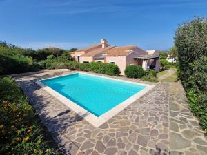 a swimming pool in front of a house at Villa Iris in Stintino
