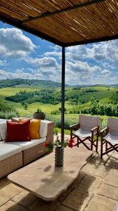 eine Couch und Stühle auf einer Terrasse mit Aussicht in der Unterkunft Tenuta Poggio Al Tufo in Certaldo