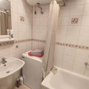 a white bathroom with a sink and a tub and a shower at Romantik Apartment with Self-Check-in in Staré Mesto