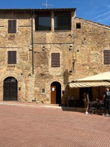 un gran edificio de ladrillo con una tienda delante de él en A La Casa Dei Potenti en San Gimignano