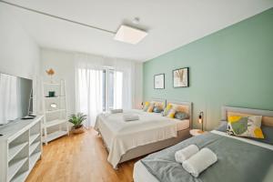 1 dormitorio con 2 camas y TV de pantalla plana en Salí Homes R4 - hochwertiges Apartment mit Terrasse en Bayreuth