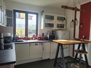 a kitchen with white cabinets and a table in it at Achims Hüttl in Bad Berka