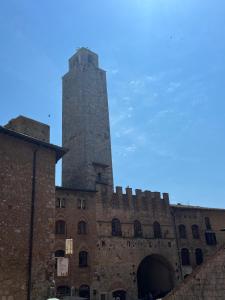 an old building with a tall tower in the background at A La Casa Dei Potenti in San Gimignano