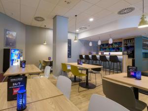 ein Restaurant mit Tischen und Stühlen und eine Bar in der Unterkunft ibis Hotel Frankfurt Messe West in Frankfurt am Main