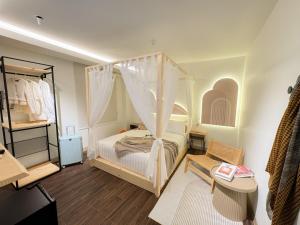 a bedroom with a canopy bed and a dressing room at Apple 1 Hotel Queensbay in Bayan Lepas