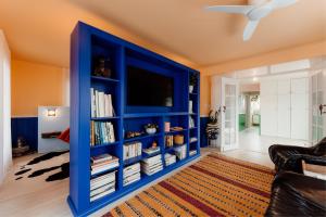 a living room with a blue book shelf at Sunny Beach Box in Sunderland Bay