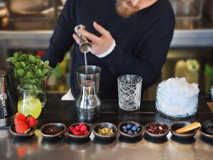 a woman is making a drink with bowls of fruit at Novotel Barcelona City in Barcelona