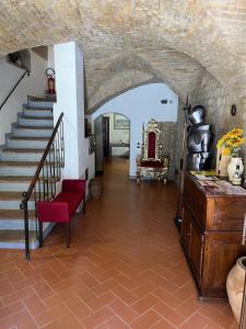 a hallway with a staircase with a red bench and a red chair at A La Casa Dei Potenti in San Gimignano