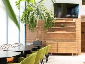 un restaurante con mesas y sillas verdes en Aparthotel Adagio Bordeaux Centre Gambetta, en Burdeos