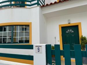 uma casa com uma porta verde e uma cerca em Comporta Centro Villa 3 quartos MHouse lease em Comporta