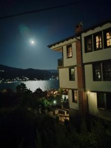 a building with a view of the water at night at Villa Lollobrigida in Ohrid