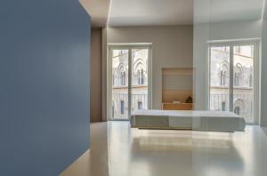 Fiveplace Design Suites & Apartments في تراباني: غرفة نوم بسرير ونوافذ كبيرة
