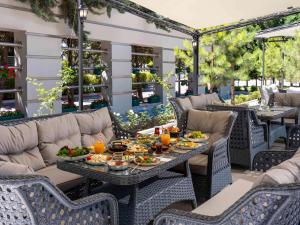 zewnętrzne patio ze stołem i jedzeniem w obiekcie Novotel Kayseri w mieście Balqash