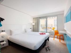 a hotel room with a bed and a balcony at Ibis Styles Menton Centre in Menton