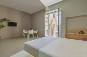 una camera con un grande letto e un tavolo di Fiveplace Design Suites & Apartments a Trapani