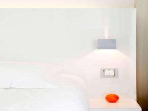 an orange sitting on a table next to a bed at Ibis Styles Menton Centre in Menton