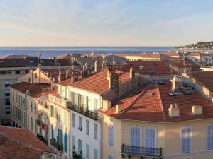 a view of roofs of buildings and the ocean at Ibis Styles Menton Centre in Menton