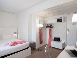 a bedroom with a bed and a desk with a computer at Ibis Styles Menton Centre in Menton