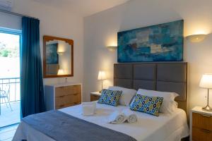 een slaapkamer met een bed met twee handdoeken erop bij Apartamentos - Solar Vale Covo in Carvoeiro