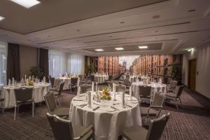 a banquet room with white tables and chairs and a painting at Best Western Plus Hotel Böttcherhof in Hamburg