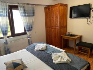 een slaapkamer met een bed met twee handdoeken erop bij Pensiunea Bianca in Bran