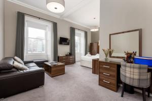 uma sala de estar com um sofá e um espelho em 28 York Place Hotel em Edimburgo