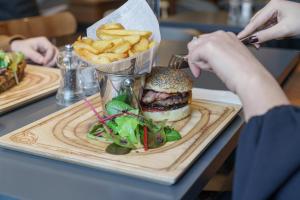 une personne mangeant un hamburger et des frites sur une table dans l'établissement L'Elysée Val d'Europe, à Serris 27 autres photos