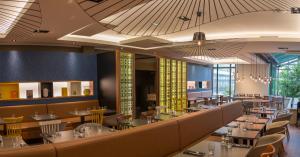 d'une salle à manger avec des tables, des chaises et des plafonds. dans l'établissement L'Elysée Val d'Europe, à Serris