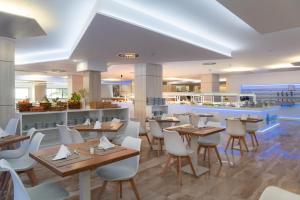 a restaurant with wooden tables and white chairs at Sandos Griego in Torremolinos +33 photos