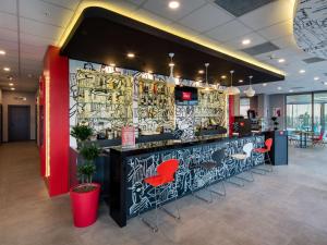 a bar with red chairs and a wall covered in graffiti at Ibis Istanbul West in Istanbul