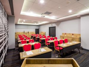 una sala conferenze con tavoli e sedie rosse di Ibis Istanbul West a Istanbul