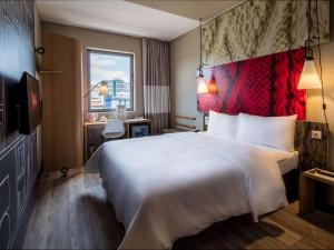 una camera d'albergo con un grande letto e una scrivania di Ibis Istanbul West a Istanbul