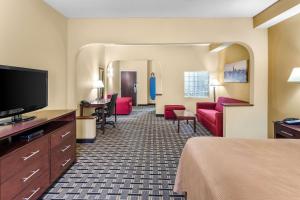 a hotel room with a bed and a flat screen tv at Clarion Inn & Suites Northwest in Indianapolis